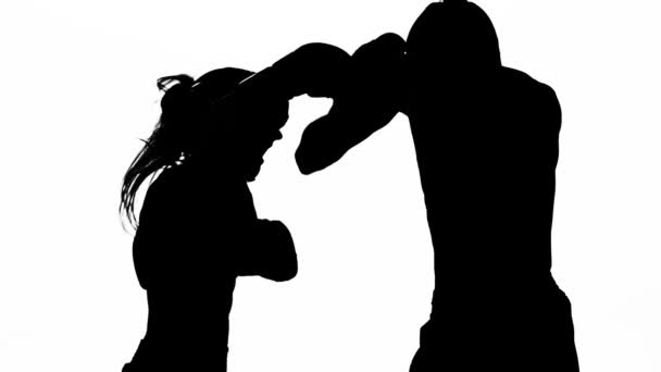 男人和一个女孩拳击手套打在戒指上。剪影。白色背景。慢动作 — 图库视频影像