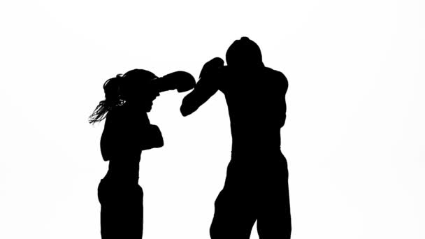Men with a girl kickboxing gloves beating in the ring . Silhouette. White background. Slow motion — Stock Video