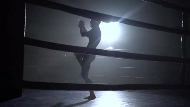 Atlet trenler karanlık bir boşluk ringde bir spot ışığı parlıyor