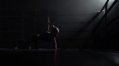 Kız karanlık ringde yerden sıkar. Siluet