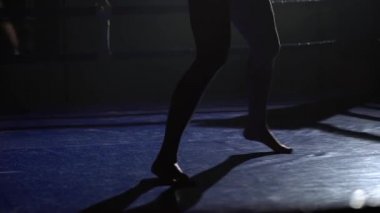 Atlet trenler karanlık bir boşluk ringde bir spot ışığı parlıyor. Siluet
