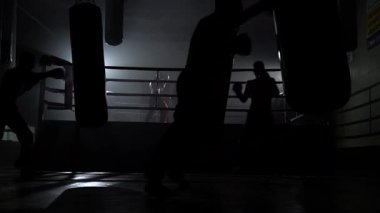 Karanlık bir ringde bir armut yenerek kickboxers