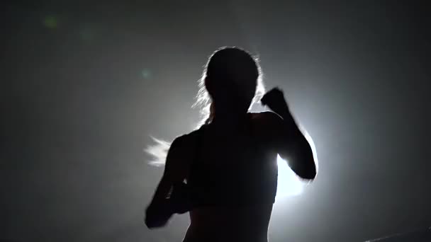 Treinen van de atleet in de ring een donkere ring schijnt een middelpunt van de belangstelling. Silhouet. Licht van achter — Stockvideo