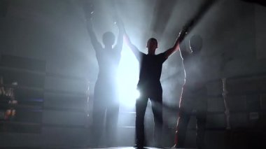 Hakem kickboks, beraberlik sonucu duyurdu. Duman. Arkadan ışık. Siluet