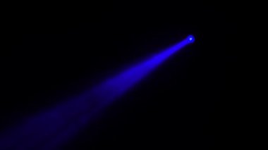 Siyah bir arka plan üzerinde renkli kirişler bir projektör döner