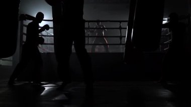Çocuklar eldiven işte kickboxers fikir tartışması ringde arka planda bir armut atıyor. Ağır çekim