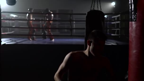 Eldiven erkeklerde işte kickboxers fikir tartışması ringde arka planda bir armut atıyor. Ağır çekim — Stok video