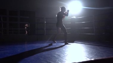 Kız Kick Boks rekabet, o trenler gece içinde belgili tanımlık çalmak için hazırlanıyor. Siluet. Ağır çekim