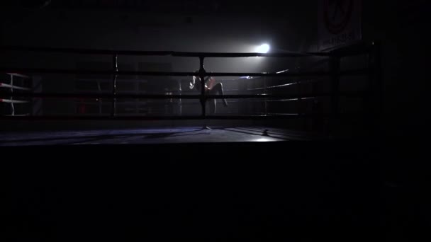 Atleet treinen in de donkere ring slaat haar benen. Silhouet. Slow motion — Stockvideo