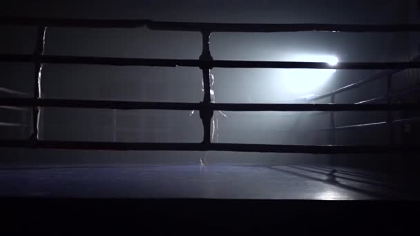 Frau beim Seilspringen in einem dunklen Raum. Silhouette. Zeitlupe — Stockvideo