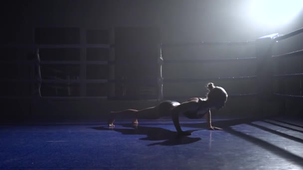 Girl squeezes off the floor in the dark ring. Silhouette. Slow motion — Stock Video
