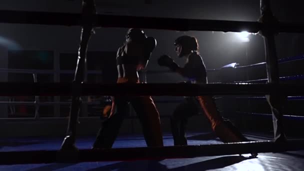 Sparring i ringen mellan två flickor i ett mörkt utrymme. Slow motion — Stockvideo