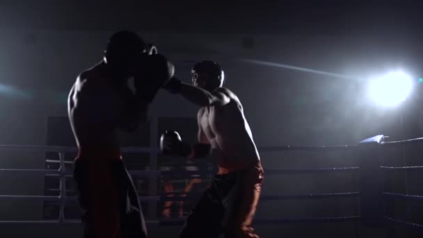 Dos tipos preparándose para las competiciones de kickboxing. En cámara lenta. Silueta — Vídeos de Stock