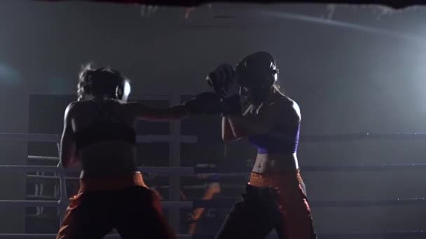 Sparring im Ring zwischen zwei Mädchen in einem dunklen Raum. Zeitlupe — Stockvideo