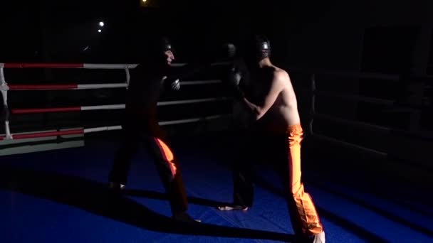 Dois tipos no ringue lutam no escuro. Movimento lento — Vídeo de Stock