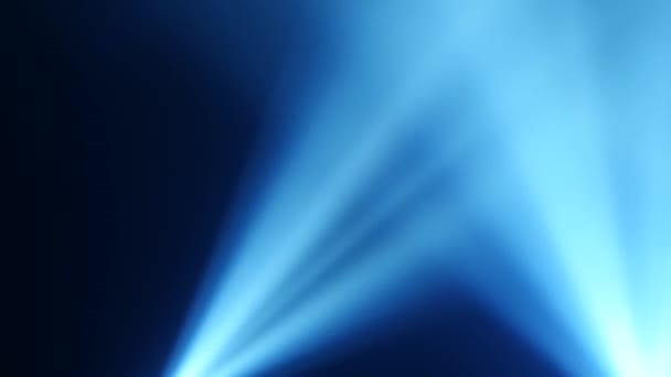 Raggi di luce blu dai proiettori su uno sfondo nero fumo — Video Stock