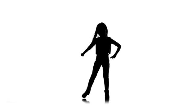 Baby raises her leg up in studio. White background. Silhouette. Slow motion — Stock Video