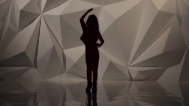 Bebek studio bacağını yükseltir. Siluet. Ağır çekim. Geometrik arka plan