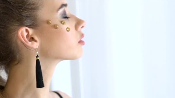 Model with rhinestones on her face posing in front of the cameras. Slow motion — Stock Video