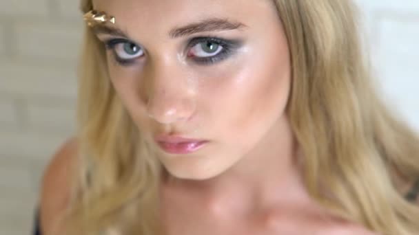 그녀의 얼굴의 포즈에 rhinestones와 모델. 근접 촬영입니다. 슬로우 모션 — 비디오