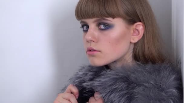 Meisje met mooie make-up wordt gekeken naar de camera. Close-up. Slow motion — Stockvideo