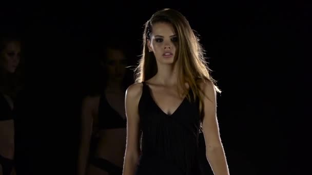 Fashion shows in a swimsuit. Black background. Slow motion — Stock Video