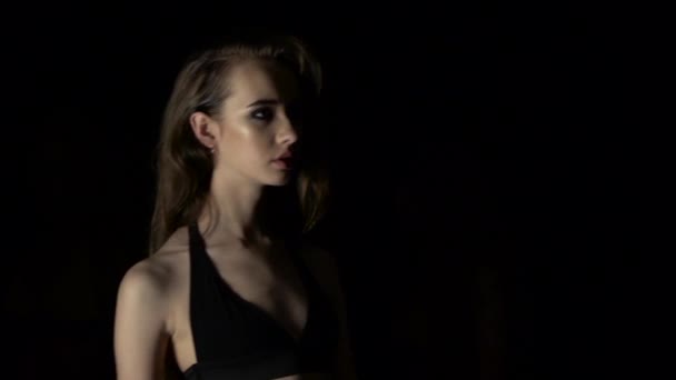 Fashion shows in a swimsuit. Black background. Close up. Slow motion — Stock Video