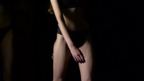 Girls legs walking down catwalk closeup. Black background. Slow motion — Stock Video