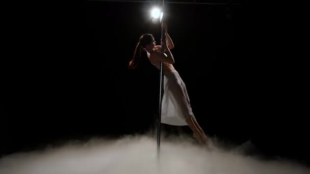 Girl is dancing near the pole erotic dancing in smoke. Black smoke background. Slow motion — Stock Video