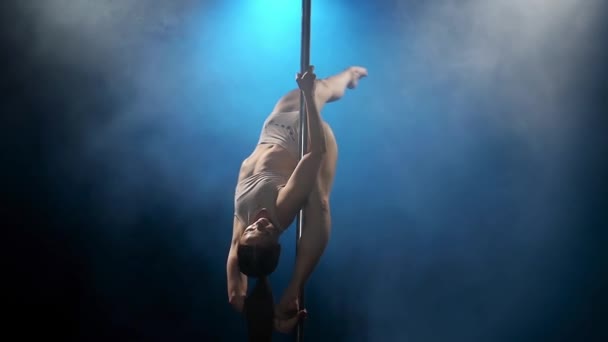 Striptease dancer in blue smoke on a pole. Blue smoke background. Slow motion — Stock Video