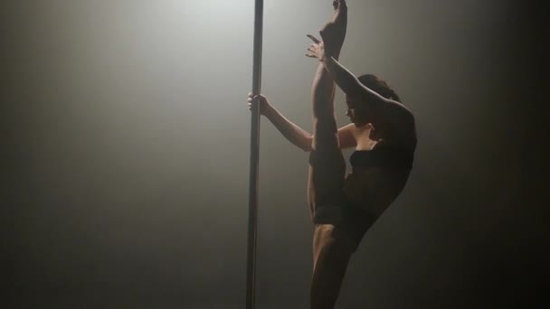 Woman dancing near the pole erotic dancing. Black background. Slow motion — Stock Video