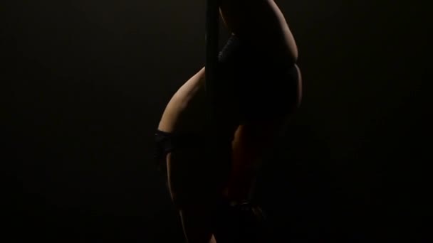 Female poledance on pole at dance night club. Black background. Slow motion. Close up — Stock Video