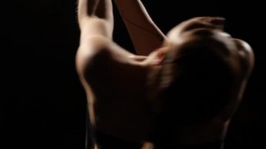 Kız kolayca adımları pilon üzerinde dans ediyorsun. Siyah arka plan. Yakın çekim. Ağır çekim