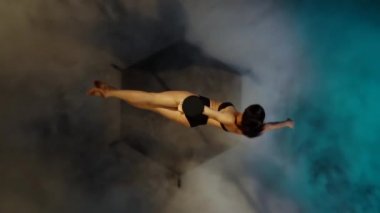 Dansçı ve kutup mavi duman spin hileler gerçekleştirir. Ağır çekim. Üstten görünüm