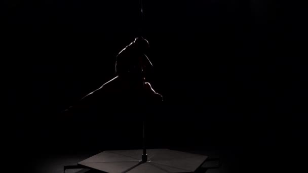 Mouvement acrobatique sur le poteau. Fond noir. Au ralenti. Silhouette — Video