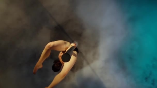 Flickan dansar på en stolpe. Blå rök bakgrund. Slow motion. Ovanifrån — Stockvideo