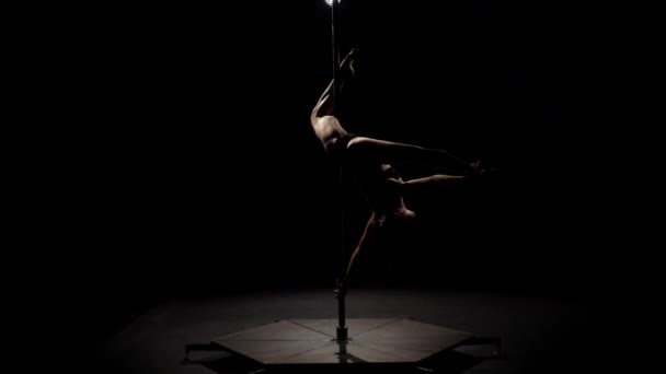 Ballerina che gira su un palo. Fondo nero. Al rallentatore. Silhouette — Video Stock