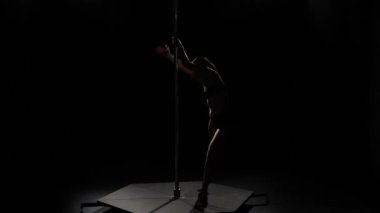 Bir dans bir pilon üzerinde dans kız. Siyah arka plan. Siluet
