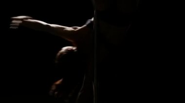 Kız kutup dans dans ediyor. Siyah arka plan. Siluet. Yakın çekim