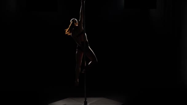 Dame mit guter Figur tanzt auf Pylon. schwarzer Hintergrund. Silhouette — Stockvideo