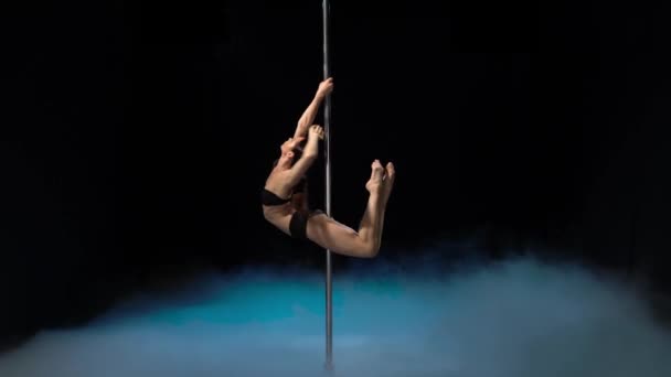 Stage strong girl performs acrobatic trick . Black smoke background — Stock Video