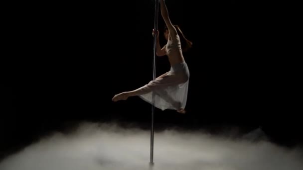 Lány táncol egy rúdra a sötét füstöt stúdióban. Fekete füst háttér — Stock videók