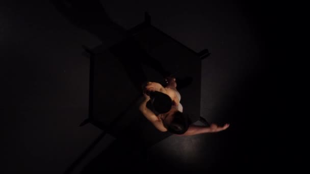 Dancer in underwear spinning on a pole . Black background. Top view — Stock Video