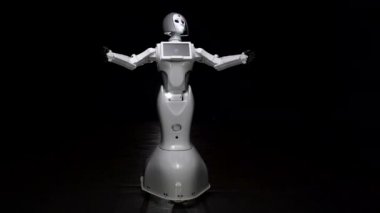 Robot görüşmeler ve hareketler yapar. Siyah arka plan