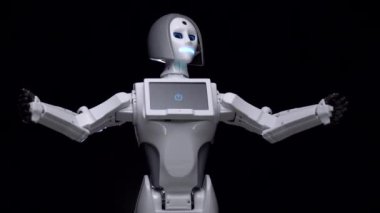 Robot konuşuyor ve kendi elleriyle jestleri. Siyah arka plan