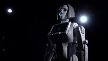 Kenarlarda ışık ile karanlık bir odada şu robot standları ve görünüyor. Siyah arka plan