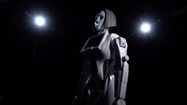 Ρομπότ στέκεται και κοιτάζει ίσια. Μαύρο φόντο — Αρχείο Βίντεο
