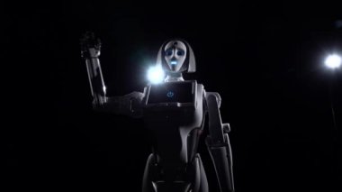 Robot konuşuyor ve çeşitli hareketler hoşça kal yinelenir. Siyah arka plan