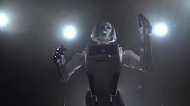 Robot konuşan ve farklı hareketleri tekrarlar. Siyah duman arka plan