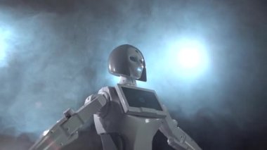 Robot ellerini yukarı yükseltir. Siyah duman arka plan. Yakın çekim